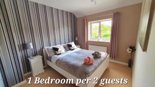 a bedroom with a bed with two stuffed animals on it at Yucca cottage in Kendal