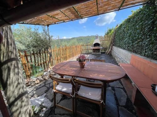 a wooden table and chairs on a patio at Medieval Tuscan Town House in Lucolena in Chianti