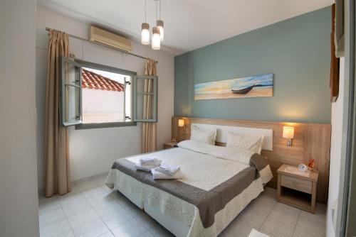 een slaapkamer met een bed en een raam bij Dora Studios by PaxosRetreats in Gaios