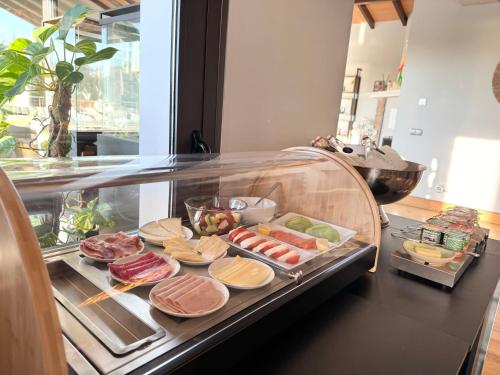 a display case with different types of food on plates at Luxury Boutique B&B - Villa Prana Marbella in Ojén
