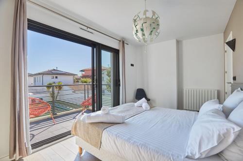 une chambre avec un lit et une grande fenêtre dans l'établissement Villas Odalys Le Domaine d Anadara, à Anglet