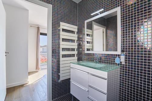 une salle de bain avec un lavabo et un miroir dans l'établissement Villas Odalys Le Domaine d Anadara, à Anglet