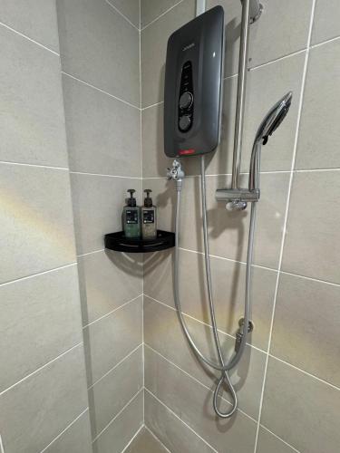 a shower with a soap dispenser in a bathroom at The Calm Corner Summermall in Kota Samarahan