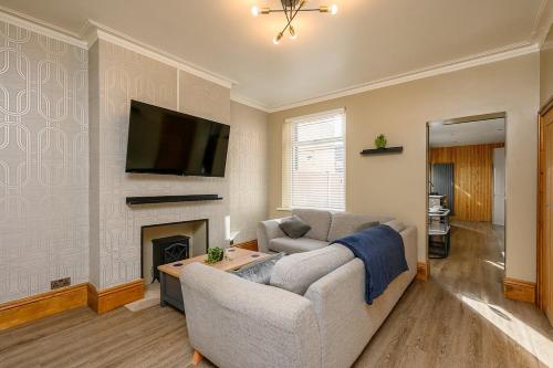 a living room with a couch and a fireplace at Brough Street 4 Bed, 5 Guests in Goole