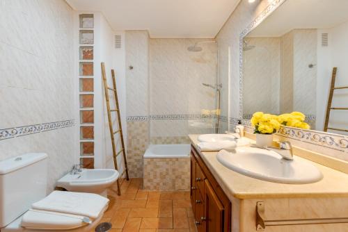 Un baño con lavabo, inodoro y espejo. en WintowinRentals Duplex en Posada del Mar, en Rincón de la Victoria