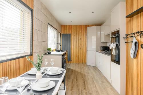 a kitchen with a table with dishes on it at Brough Street 4 Bed, 5 Guests in Goole