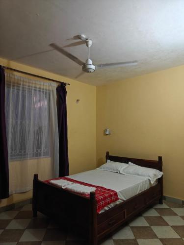 a bedroom with a bed and a ceiling fan at Creekview Retreat in Kilifi