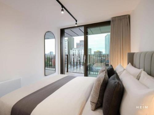 una camera da letto con un grande letto e ampie finestre di Solaro at The Heim Residences a Manchester