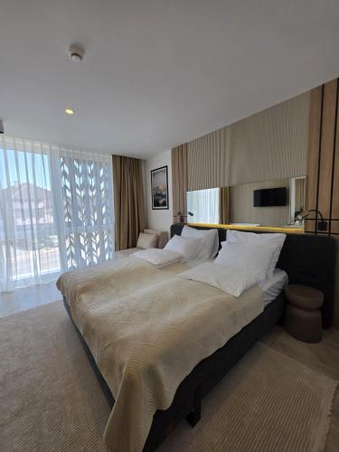 a large bedroom with two beds and a large window at Hotel Cat Deluxe in Sanski most