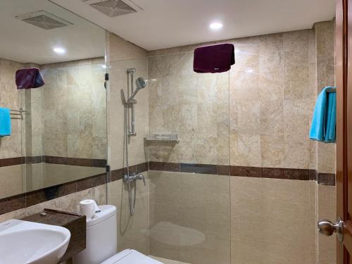 een badkamer met een douche, toilet en wastafel bij The Jayakarta Residence 2BR Bali in Denpasar