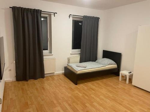 - une chambre avec un lit dans un dortoir doté de parquet dans l'établissement Holiday and fitters' apartment near Leipzig in Wurzen, à Niederdorla