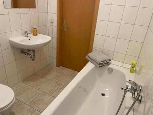 une salle de bain avec toilettes, baignoire et lavabo dans l'établissement Holiday and fitters' apartment near Leipzig in Wurzen, à Niederdorla