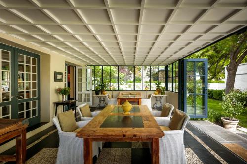 a patio with a wooden table and chairs at Grande Provence in Franschhoek
