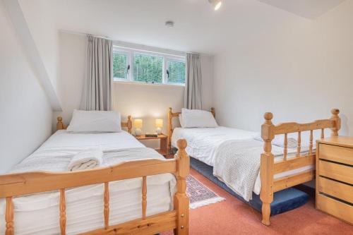 two beds in a bedroom with two windows at 2 Bed in Pooley Bridge oc-r33740 in Pooley Bridge
