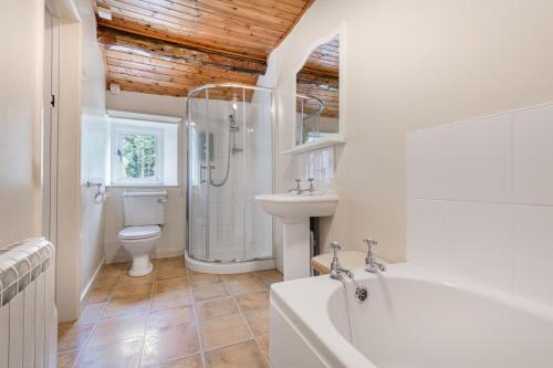 a bathroom with a tub and a toilet and a sink at 2 Bed in Pooley Bridge oc-r33740 in Pooley Bridge
