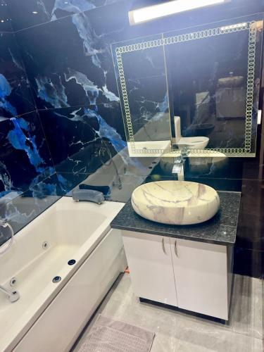 a bathroom with a tub and a sink and a mirror at Complexe Touristique Sidi Salem in Bizerte