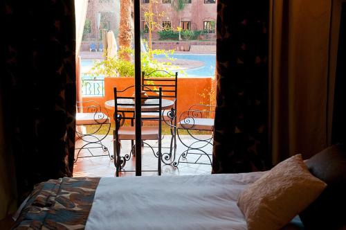 a bedroom with a bed and a view of a patio at Palacio Hôtel Condominium Marrakech in Marrakech