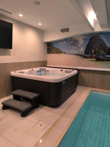 a large tub in a room with a swimming pool at Hotel Cat Deluxe in Sanski most