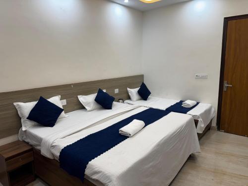 a bedroom with a large bed with blue and white pillows at Hestia Hotel and Restaurant in Greater Noida