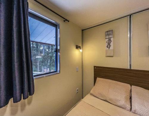 a bedroom with a bed and a window at Villa de Recriary in Campos do Jordão