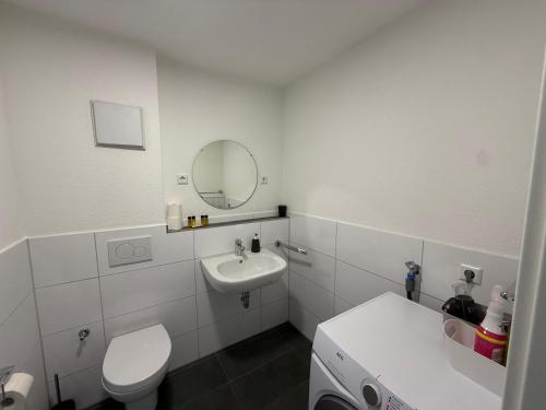 腓特烈港Deluxe Apartment Panoramablick的浴室里有洗手池、马桶和镜子。