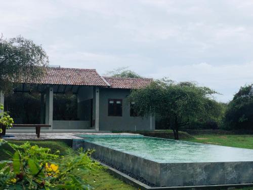 蒂瑟默哈拉默Wild loch yala的一栋房子前面有游泳池