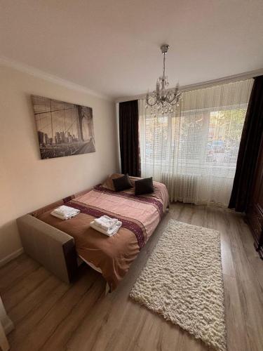 a bedroom with a bed with a rug and a chandelier at Elena Apartament in Suceava
