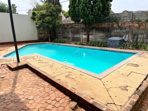 a small blue swimming pool with a brick walkway around it at 326onMackenzieSt in Pretoria