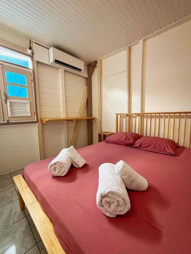 a bedroom with two towels on a bed at Kaz Créole, grande terrasse, piscine, parking in Le François