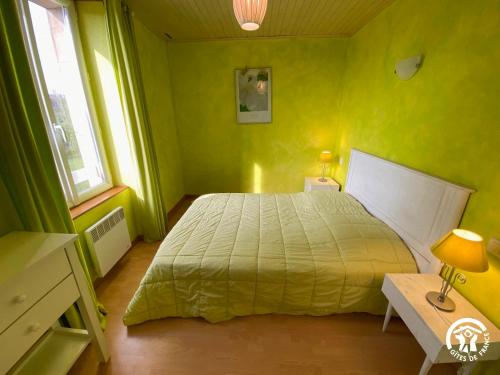 ein grünes Schlafzimmer mit einem Bett und einem Tisch in der Unterkunft Bel Air in Peyrusse-le-Roc