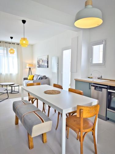 a kitchen and living room with a white table and chairs at Maison Du Marché in La Rochelle