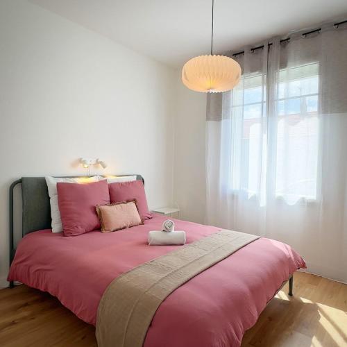 a bedroom with a pink bed with a pink blanket at Maison Du Marché, chaleureuse, proche de Île de Ré in La Rochelle