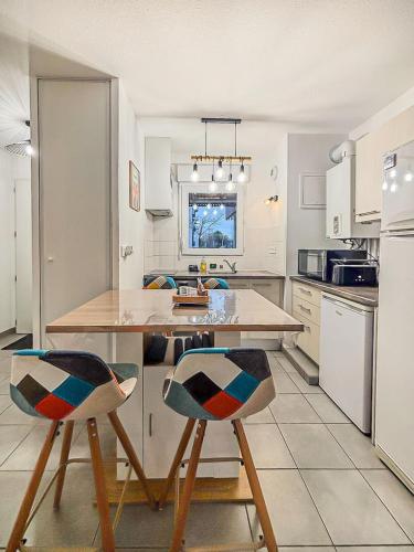 une cuisine avec une table et deux chaises. dans l'établissement Le Saint Éloi, à La Rochelle