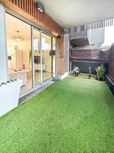 an empty living room with a green carpet at Le Saint Éloi, Terrasse, confortable et parking in La Rochelle
