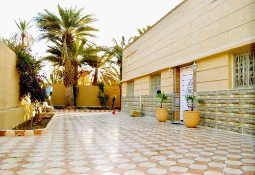 un patio con un edificio y palmeras en Premium Villa - A Peaceful Retreat 5 min from Erfoud City Centre, en Erfoud