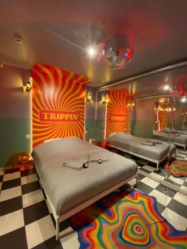 um quarto com 2 camas e um piso em xadrez em Capsule illusion - Balneo - Switch 2 - Mons Centre em Mons