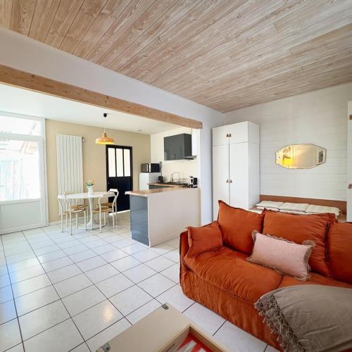 a living room with a couch and a kitchen at Maloquet in La Rochelle