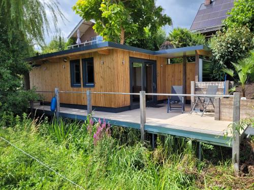 a tiny house on a dock with a porch at Prins van Poederoijen in Poederoijen
