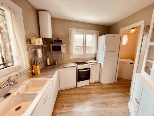 une cuisine avec un réfrigérateur blanc et un évier dans l'établissement Apartamento en Girona, à Tor