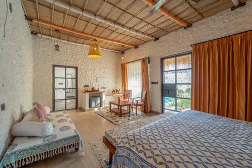 a bedroom with a bed and a desk in a room at Dunes & You - A Desert Retreat in Govindgarh