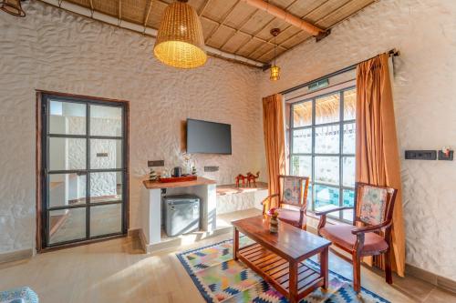 a living room with a table and a fireplace at Dunes & You - A Desert Retreat in Govindgarh