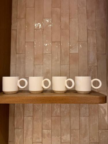 地拉那Luxury Flat In Tirana的木架上一排白杯子