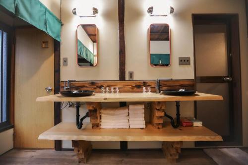 une salle de bain avec un lavabo et un grand miroir dans l'établissement 東京下町生活, à Tokyo