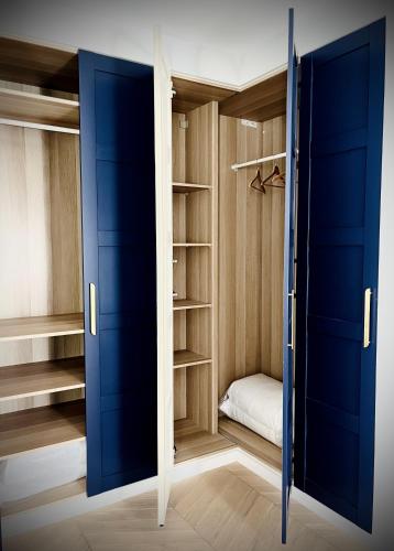 a walk in closet with blue doors and shelves at Palais Wieserfeld in Steyr