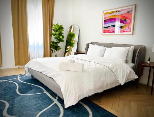 a bedroom with a large white bed with a blue rug at Palais Wieserfeld in Steyr