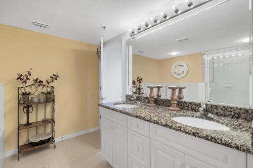 een badkamer met twee wastafels en een grote spiegel bij Oceanwalk 11-603 in Bottle Island