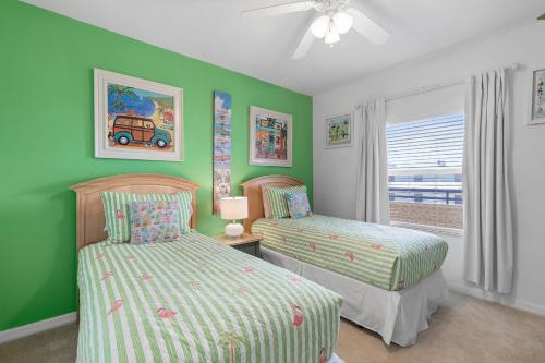 twee bedden in een kamer met groene muren en een raam bij Oceanwalk 11-603 in Bottle Island