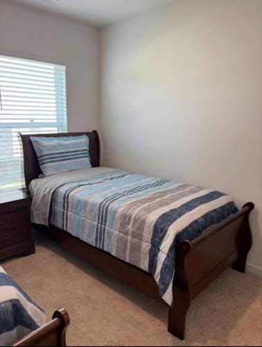 a bedroom with a bed with a striped blanket and a window at Wilson Retreat in Wilson