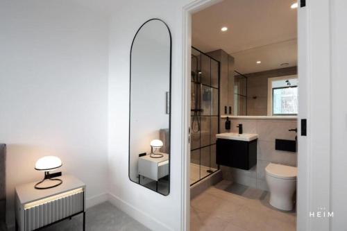a bathroom with a toilet and a sink and a mirror at Urbano at The Heim Residences in Manchester