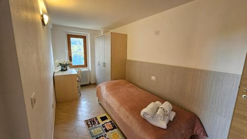 Un dormitorio con una cama con dos toallas encima. en Casa del Bitto, en Pedesina